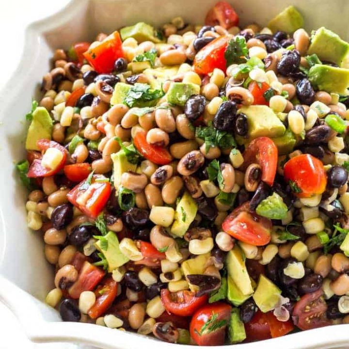 Cowboy Caviar - One of our favorite appetizers. Beans, avocado, tomatoes, and corn tossed in a light dressing. the-girl-who-ate-everything.com