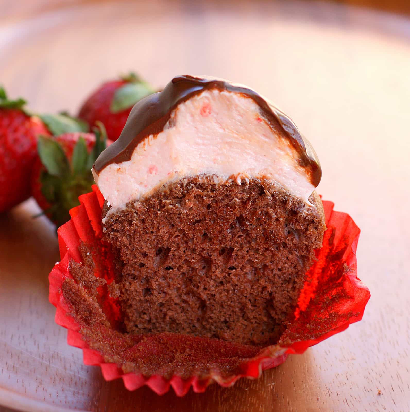 Strawberry Puffcakes - chocolate cupcakes topped with strawberry cream and dipped in chocolate. the-girl-who-ate-everything.com