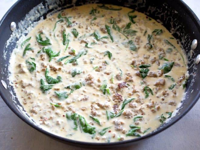 cream, sausage, and spinach in a pan