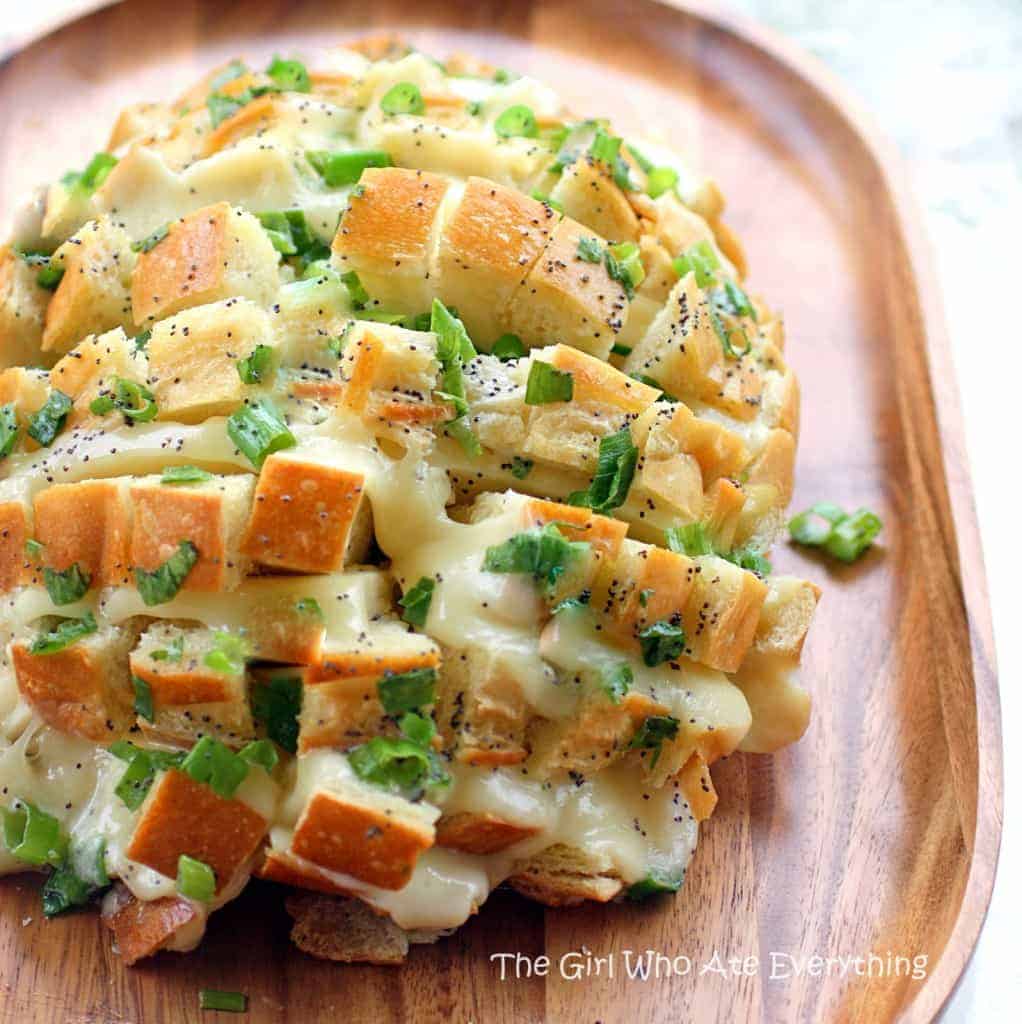 This Bloomin' Onion Bread is sourdough bread stuffed with cheese, onions, and topped with a buttery poppy seed sauce. the-girl-who-ate-everything.com