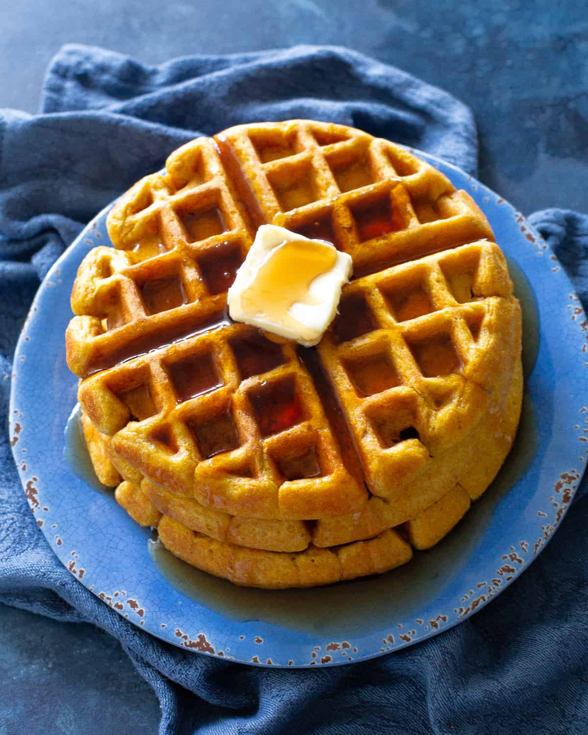 pumpkin waffles with butter on a blue plate