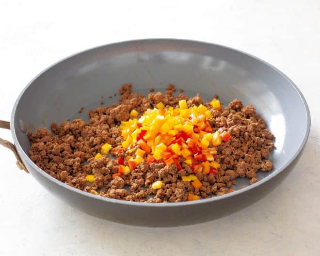 taco meat in a pan with diced stuffed peppers