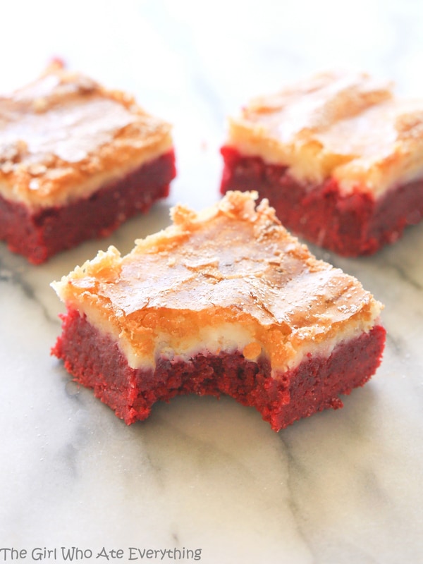 These Red Velvet Gooey Butter Bars are moist red velvet cake topped with a buttery cream cheese layer. Great for Halloween, Christmas, Valentine's Day, or the Fourth of July. the-girl-who-ate-everything.com