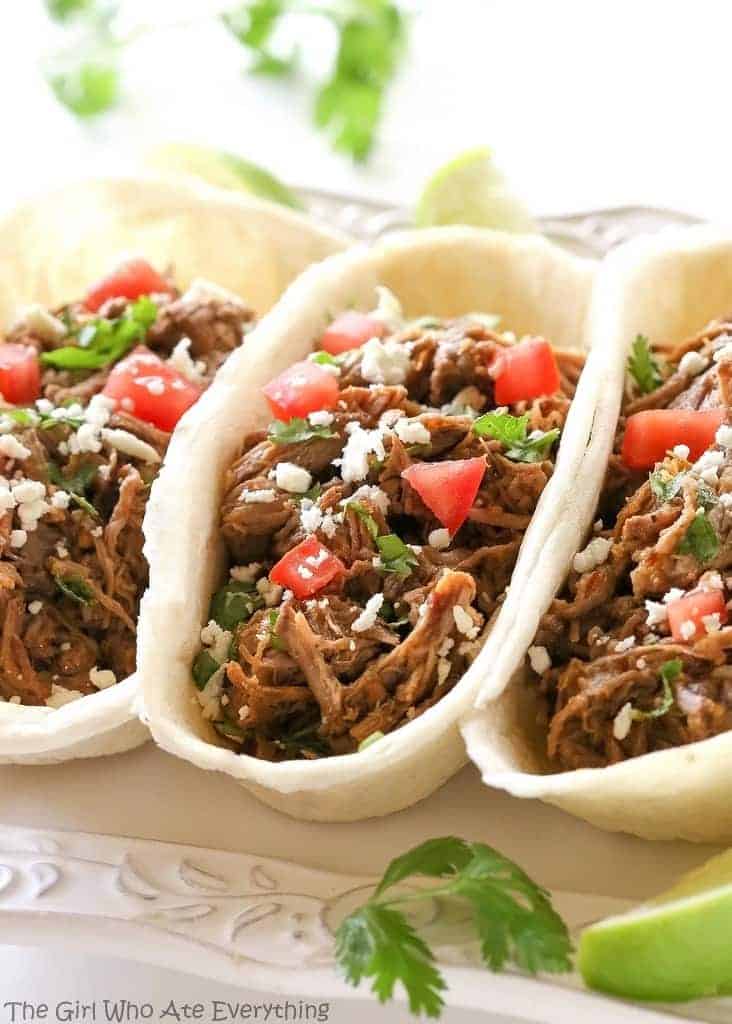 These Barbacoa Tacos are cooked in the slow cooker all day so you can come home to savory and spicy tacos. the-girl-who-ate-everything.com
