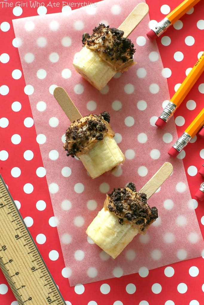 These Banana Peanut Butter Pops are bananas dipped in peanut butter and crushed Oreos. Everything is more fun on a stick and these are no exception. the-girl-who-ate-everything.com