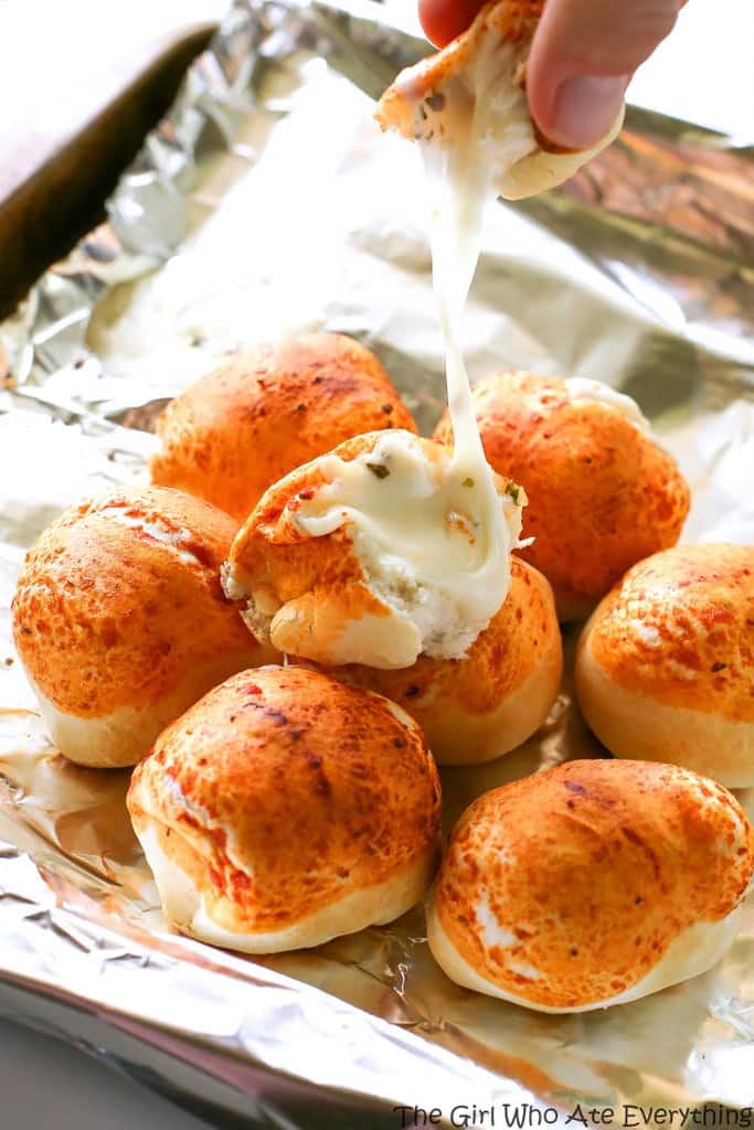 Mozzarella Puffs - dough stuffed with cubes of mozzarella cheese and brushed with pizza sauce. You could also add some pepperoni inside! These are so quick and easy. the-girl-who-ate-everything.com