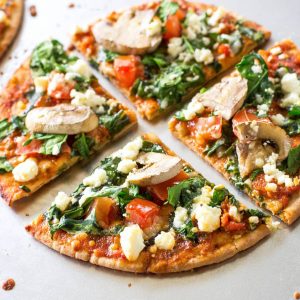 Spinach and Feta Pita Pizzas - a great appetizer or even filling enough for a meal. Only 350 calories per pizza.. the-girl-who-ate-everything.com
