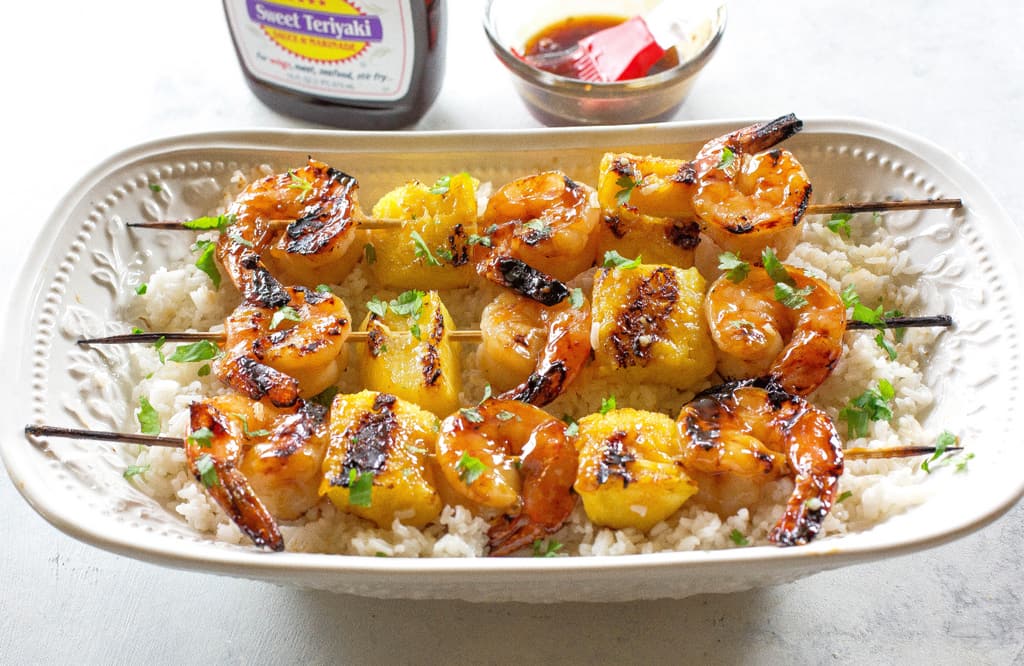These Grilled Shrimp and Pineapple Skewers are served over coconut rice and have a sweet Teriyaki glaze. the-girl-who-ate-everything.com