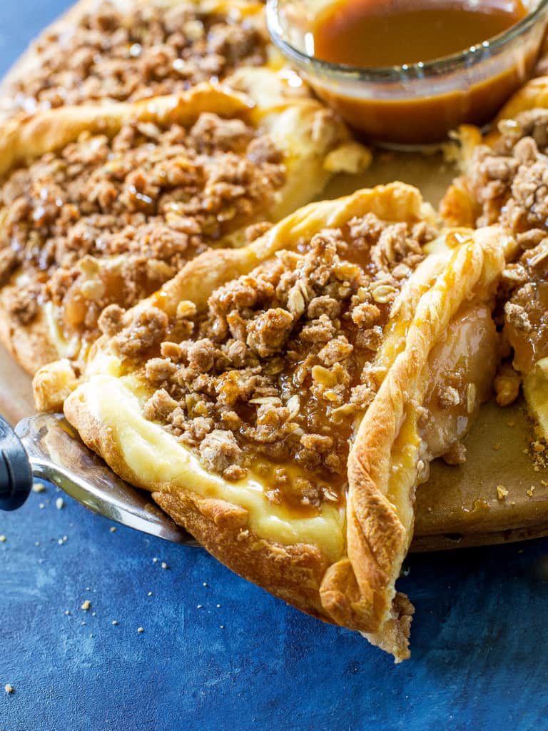 This Apple Crisp Cheese Danish recipe is a creamy cheesecake filling with a lots of oat and cinnamon topping piled on top of crescent dough. the-girl-who-ate-everything.com
