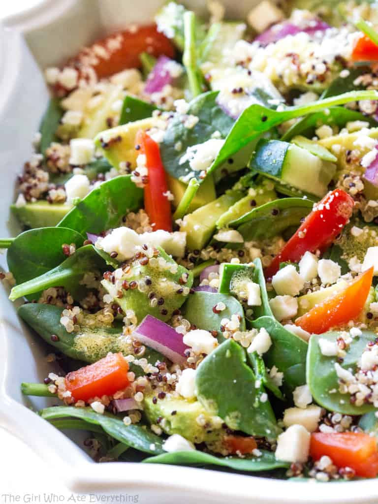 Spinach Quinoa Salad - full of rich healthy foods like cucumber, red bell pepper, avocado, and onion. This recipe is topped with a lemon dijon vinaigrette. the-girl-who-ate-everything.com