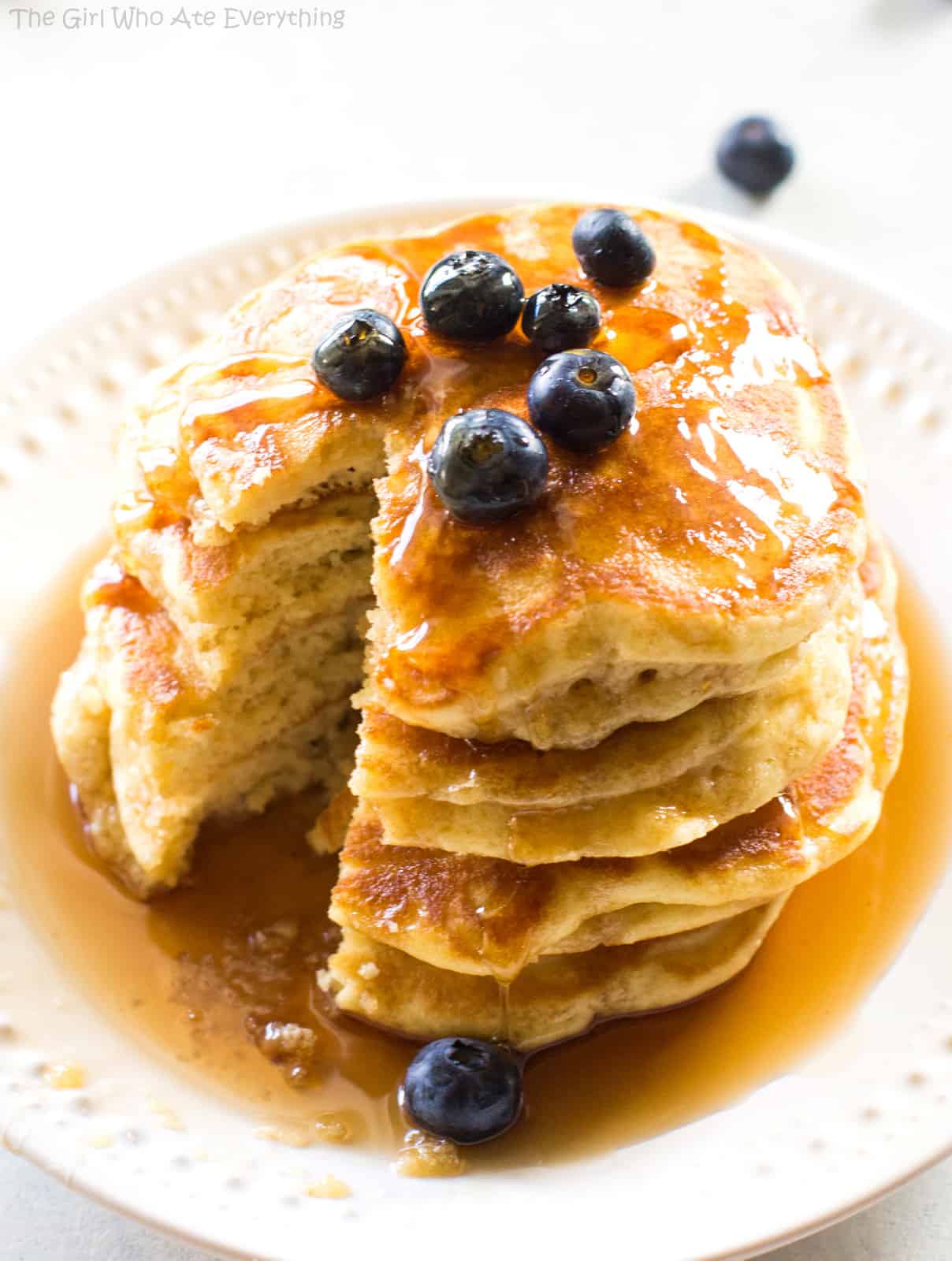 Fluffy pancakes and blueberries with syrup on a plate