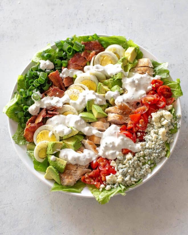cobb salad in bowl with dressing