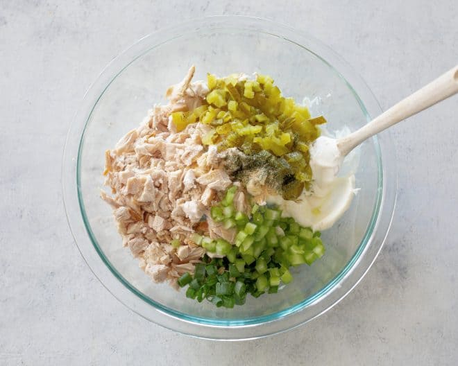 chicken, pickles, green onions, celery, and mayo in a bowl.