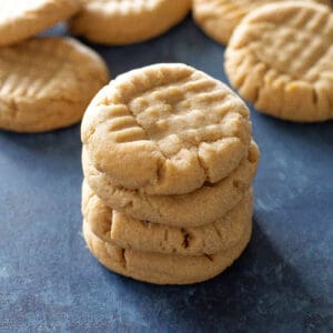 peanut butter cookies in a stack on a blue background
