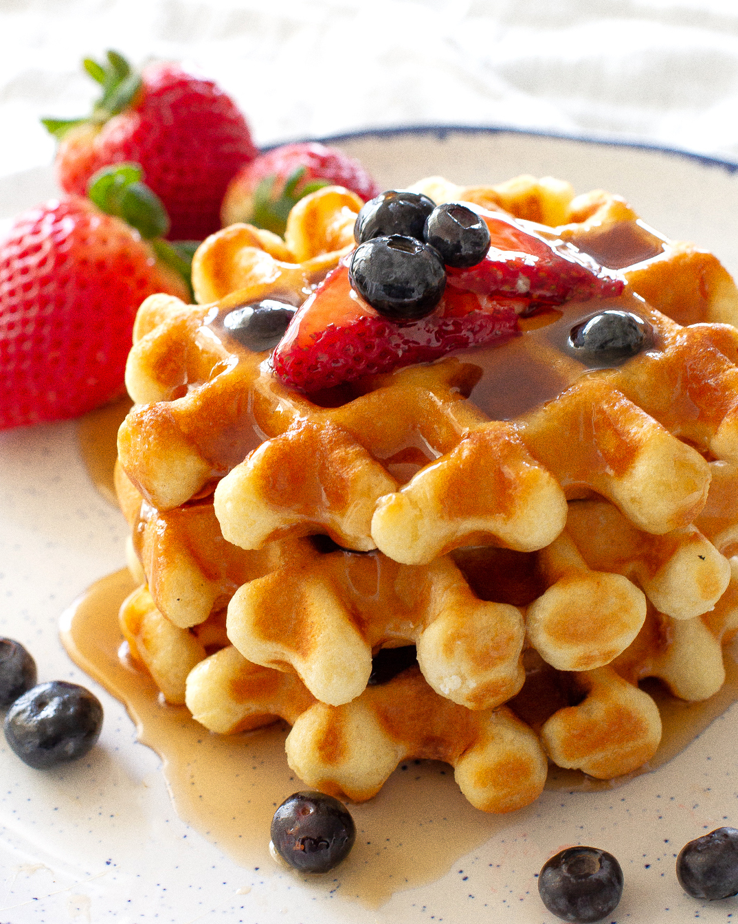 stack of waffles with strawberries and blueberries