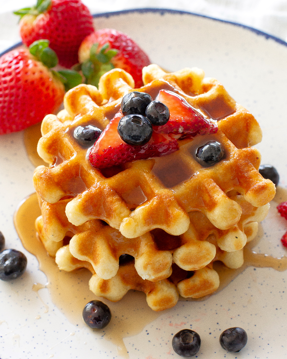 stack of waffles with strawberries and blueberries